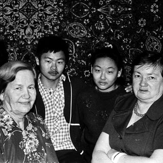 Group of five adults and two children posing indoors.