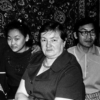 Family group portrait in traditional patterned interior.