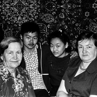 Family group portrait in traditional patterned interior.