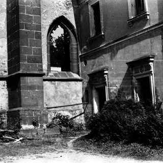 Abandoned historic building exterior with Gothic-style window.