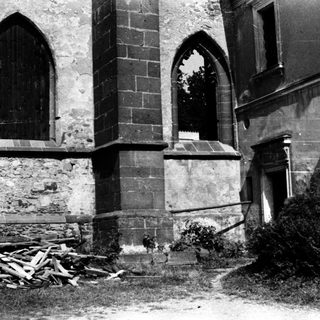Abandoned historic building exterior with Gothic-style window.