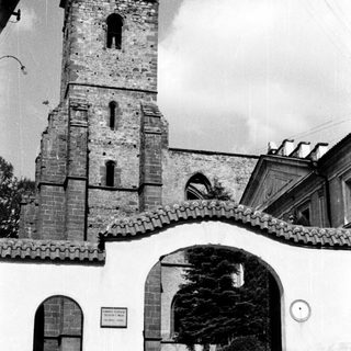 Historic stone church tower with arched entrance gate.