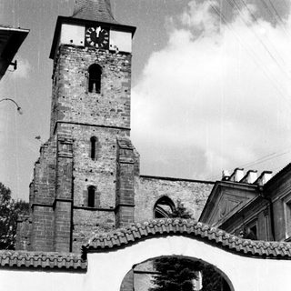 Historic stone church tower with arched entrance gate.