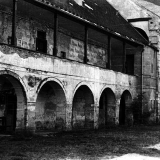 Abandoned stone building with arched ground floor.