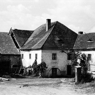 Rural farmhouse complex with aged buildings and barns.