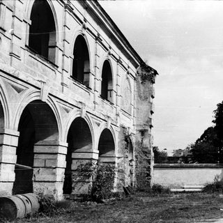 Abandoned stone building with arched columns.
