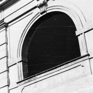 Neoclassical building facade with arched windows.