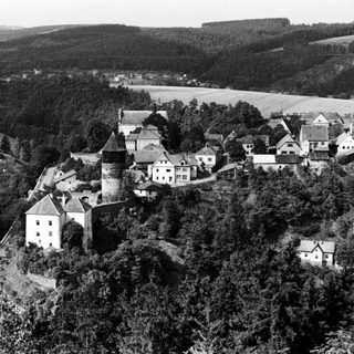 Rural village with castle ruins and clustered buildings.