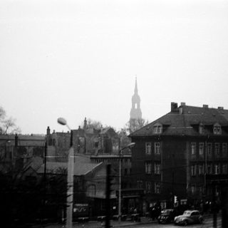 Urban street scene with historic church spire.