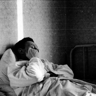 Person resting or sleeping on a bed.