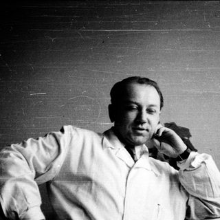 Man in white shirt talking on phone.