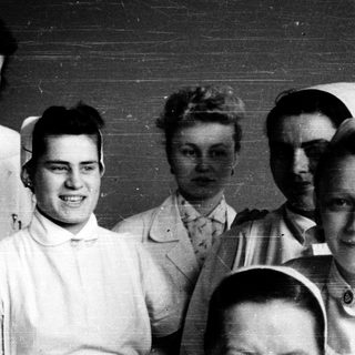 Nurses and medical staff in 1940s-era uniforms posing together.