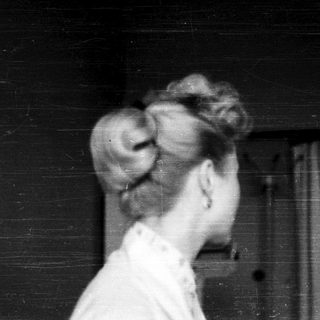 Black-and-white photo of woman with updo hairstyle.