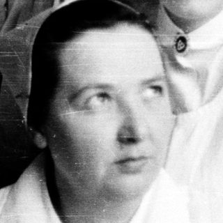 Nurses in traditional 1940s-50s uniforms posing together.