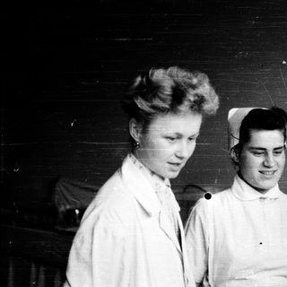 Nurses in traditional white uniforms, mid-20th century.