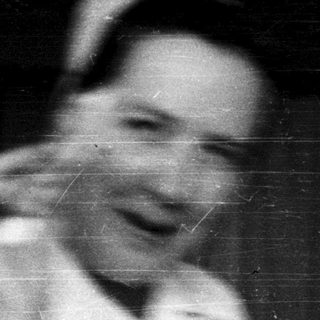 Blurred black-and-white photo of person laughing.