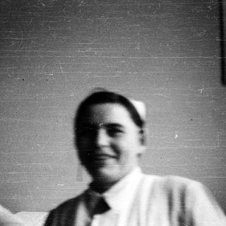 Nurses in vintage uniforms posing indoors.
