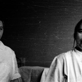 Black-and-white portrait of a person indoors.