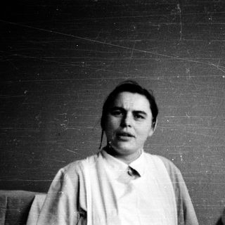 Black-and-white portrait of a person indoors.