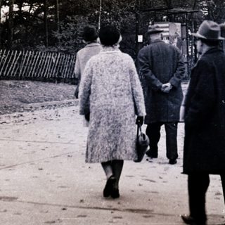 People walking on a rural roadside path.