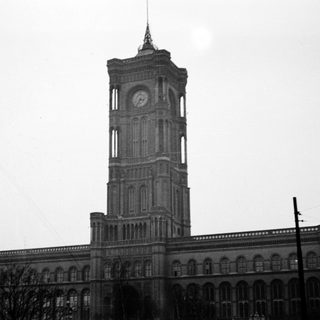 Tall clock tower on grand historic building.