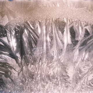 Frost patterns on a window surface.
