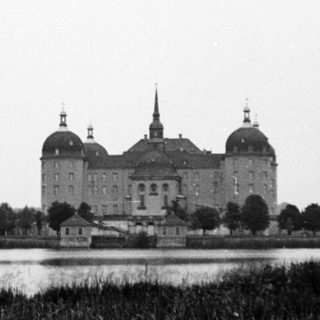 Grand historic castle by serene waterfront.