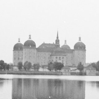 Grand castle reflected in tranquil lake.