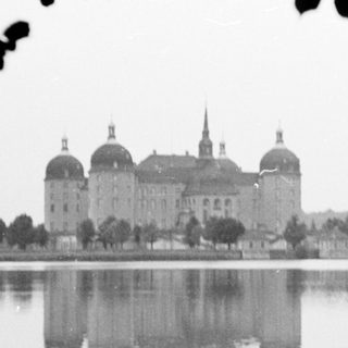 Grand castle reflected in serene lake.