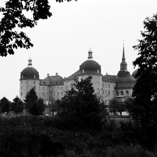 Baroque castle surrounded by trees.