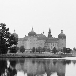 Grand palace reflected in tranquil lake.