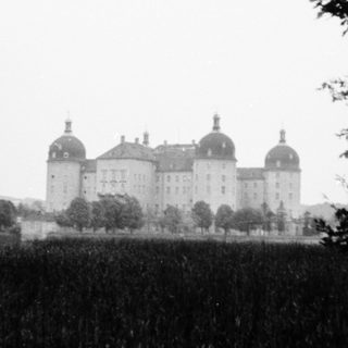 Grand historic castle with towers in rural setting.