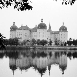 Elegant palace reflected in serene lake.