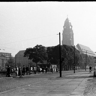 Historic city street with clock tower and church.