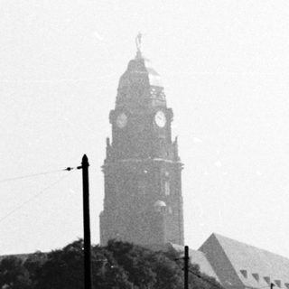 Historic city street with clock tower and church.