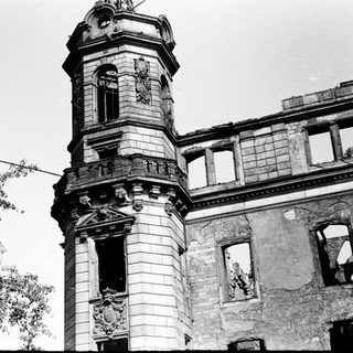 Damaged historic building with clock tower.
