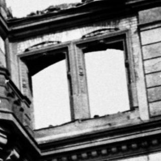 Damaged historic building with clock tower.