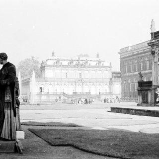 Baroque palace courtyard with statue and grand architecture.