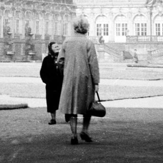 Baroque palace courtyard with two people walking.