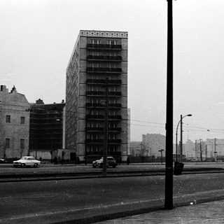 Urban scene with mid-century high-rise apartment building.