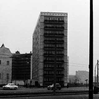 Urban scene with mid-century high-rise apartment building.