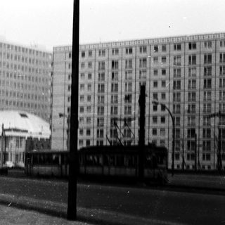 Urban street scene with tram, high-rise buildings, and snow.