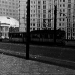 Urban street scene with tram, high-rise buildings, and snow.