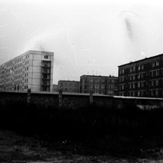 Mid-century Soviet-era apartment blocks behind fence.