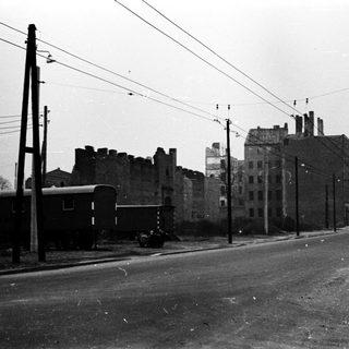 Urban street with old train cars, abandoned buildings, early 20th century.
