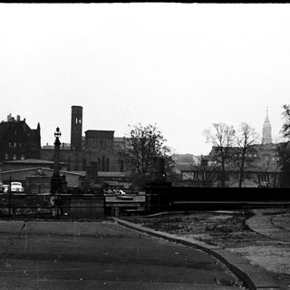 Historic cityscape with bridge, old buildings, and wartime damage.