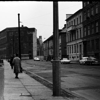 Urban street scene with pedestrian on bridge.