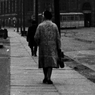 Urban street scene with pedestrian on bridge.