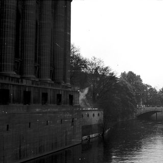 Urban canal with bridge and industrial buildings.