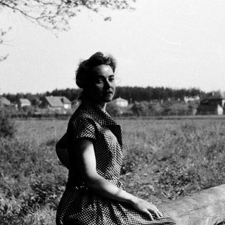 Woman posing outdoors in vintage polka-dot dress.